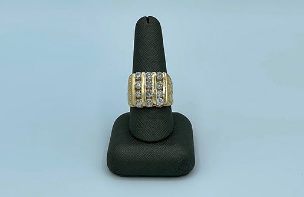 A man’s ring on display with a grey background.
