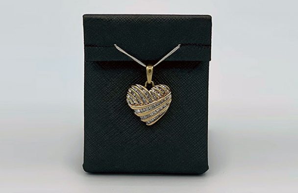 A pendant locket on display with a grey background.